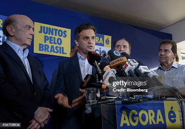 Aecio Neves, presidential candidate for the Brazilian Social Democracy Party, known as PSDB, center, speaks as senator Jose Serra, left, listens...
