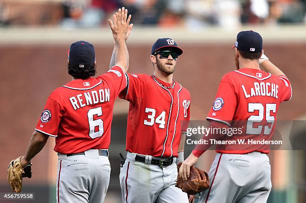 Bryce Harper celebrates with Anthony Rendon and Adam LaRoche of the Washington Nationals after their 4 to 1 win over the San Francisco Giants during...