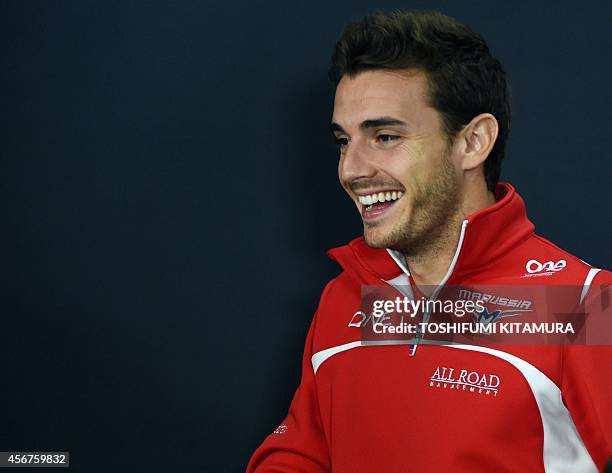 This October 2, 2014 picture shows Marussia driver Jules Bianchi of France smiling after FIA official press conference for the Japanese Formula One...