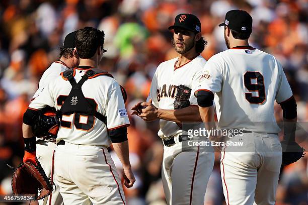 Manager Bruce Bochy meets with Madison Bumgarner Buster Posey and Brandon Belt of the San Francisco Giants on the mound during Game Three of the...