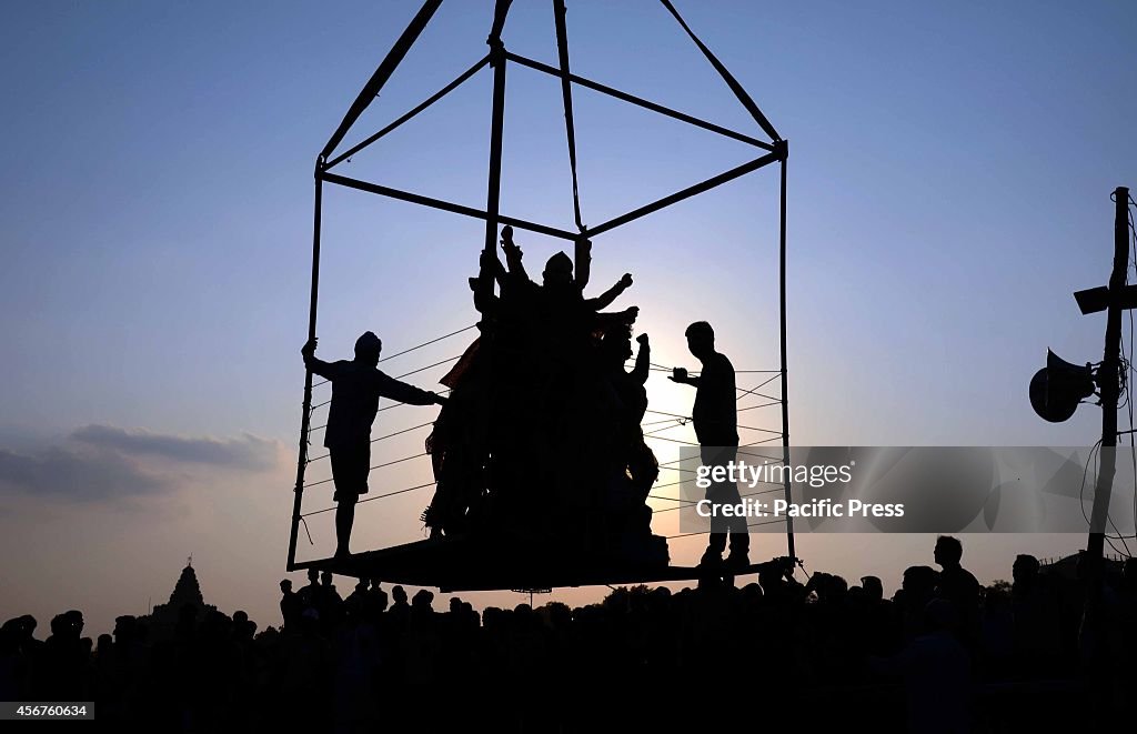 Devotees prepare to immerse an idol of the Goddess Durga...