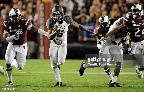 Tailback Marcus Murphy of the Missouri Tigers tries to elude defenders for the South Carolina Gamecocks during the fourth quarter on September 27,...