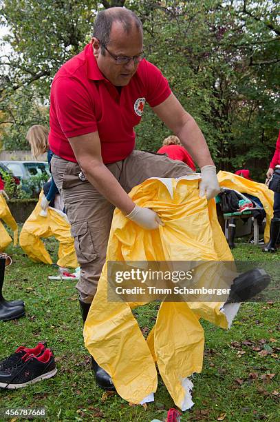 Volunteer doctor who will travel to West Africa to help care for Ebola patients puts on an isolation suit during training offered by the German Red...