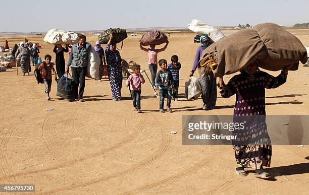 September 26: Newly arrived Syrian Kurdish refugees walk with their belongings after crossing into Turkey from the Syrian border town of Kobani on...