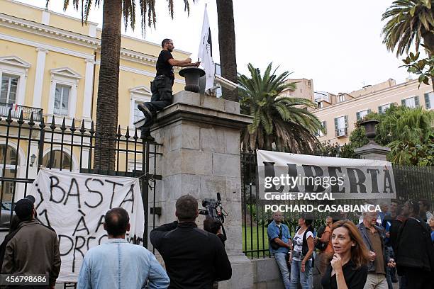 Corsican nationalist militant sets up a Corsican flag on Corsica's southern prefecture gates, on October 7 in Ajaccio, French Mediterranean island of...