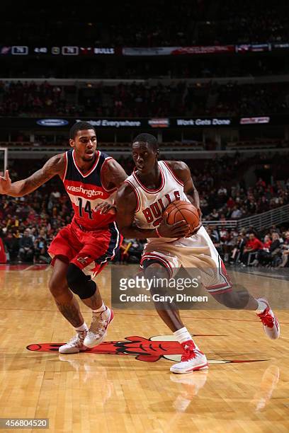 Tony Snell of the Chicago Bulls handles the ball against the Glen Rice Jr. #14 of the Washington Wizards on October 6, 2014 at the United Center in...