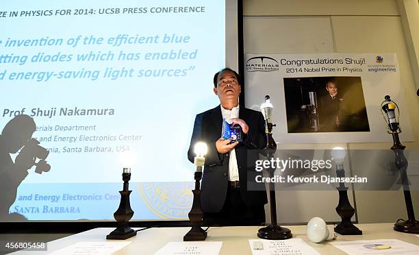 Santa Barbara scientist Shuji Nakamura demonstrates his invention of blue LED light during a news conference after winning the 2014 Nobel Prize for...