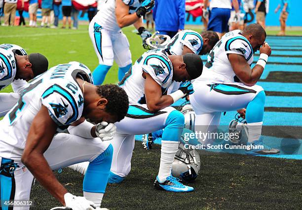 Josh Norman and Bene Benwikere the Carolina Panthers pray along with teammates before the game against the Detroit Lions at Bank of America Stadium...