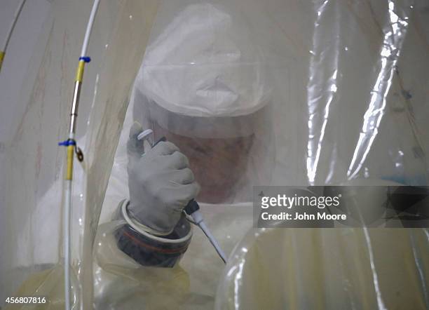 Navy microbiologist Lt. Jimmy Regeimbal tests blood samples for Ebola at the U.S. Navy mobile laboratory of on October 7, 2014 near Gbarnga in Bong...