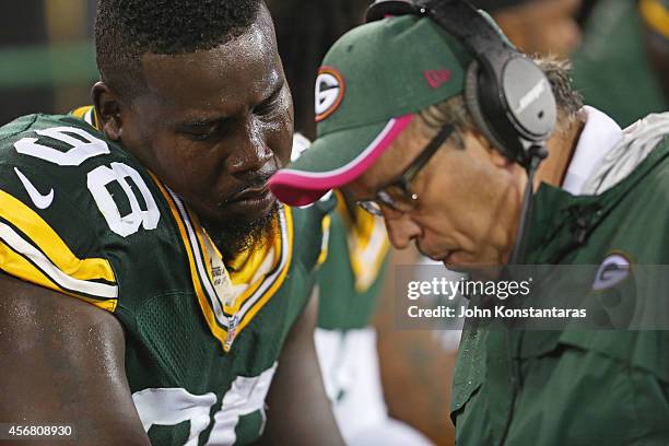 Letroy Guion of the Green Bay Packers with defensive line coach Mike Trgovac during the second quarter of the NFL game on October 02, 2014 at Lambeau...