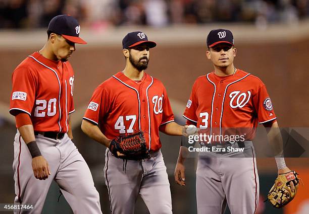 Ian Desmond and Asdrubal Cabrera talk to Gio Gonzalez of the Washington Nationals after he walked Gregor Blanco scoring Brandon Crawford of the San...