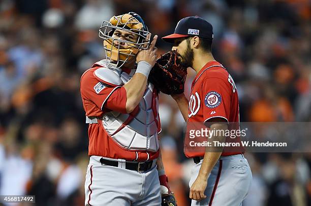 Wilson Ramos talks to Gio Gonzalez of the Washington Nationals after Gonzalez commited an error in the second inning against the San Francisco Giants...