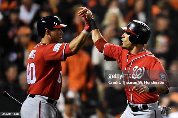 Ian Desmond celebrates with Wilson Ramos of the Washington Nationals after scoring on a RBI double by Bryce Harper in the fifth inning against the...