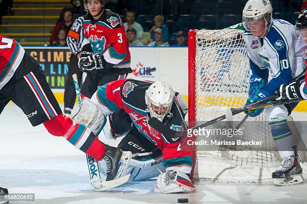 Jackson Whistle of Kelowna Rockets makes a save from a wrap around goal by Colby Cave of Swift Current Broncos on October 7, 2014 at Prospera Place...