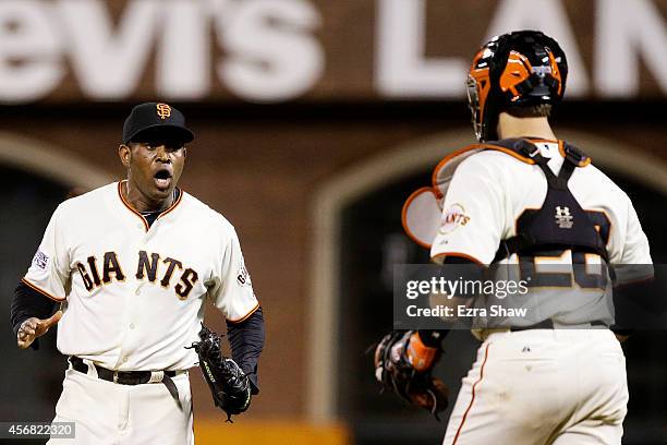 Santiago Casilla and Buster Posey of the San Francisco Giants celebrate after the final out of their 3 to 2 win over the Washington Nationals during...