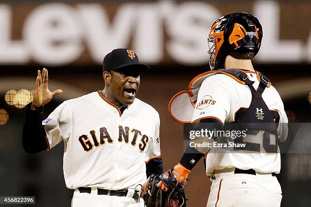 Santiago Casilla and Buster Posey of the San Francisco Giants celebrate after the final out of their 3 to 2 win over the Washington Nationals during...