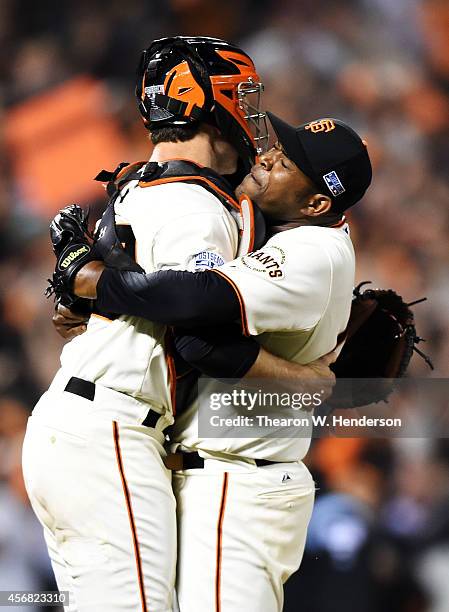 Santiago Casilla and Buster Posey of the San Francisco Giants celebrate after the final out of their 3 to 2 win over the Washington Nationals during...