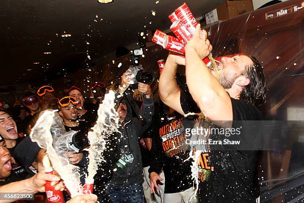 Madison Bumgarner of the San Francisco Giants celebrates in the locker room after their 3 to 2 win over the Washington Nationals in Game Four of the...