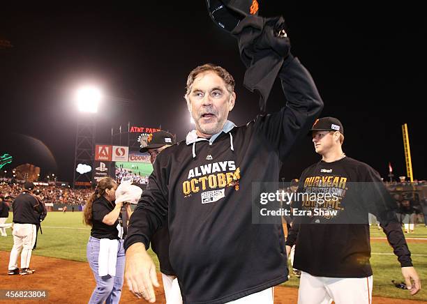 Manager Bruce Bochy waves to the crowd as he celebrates their 3 to 2 win over the Washington Nationals during Game Four of the National League...