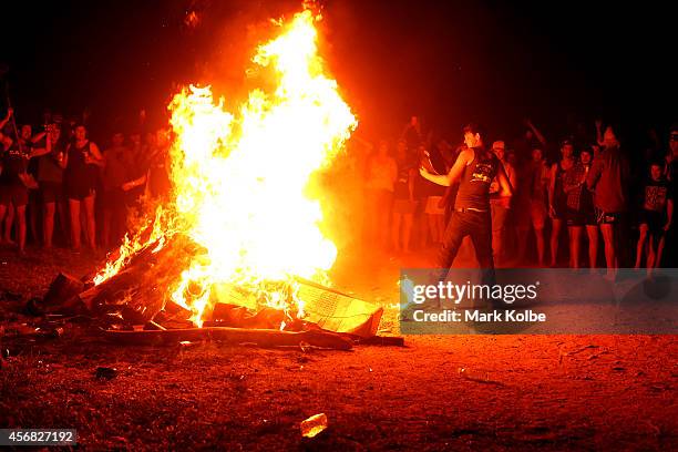 Camper kicks flames into a large fire burning in the "Ute Paddock" camp ground on the second day of the 2014 Deni Ute Muster at the Play on the...