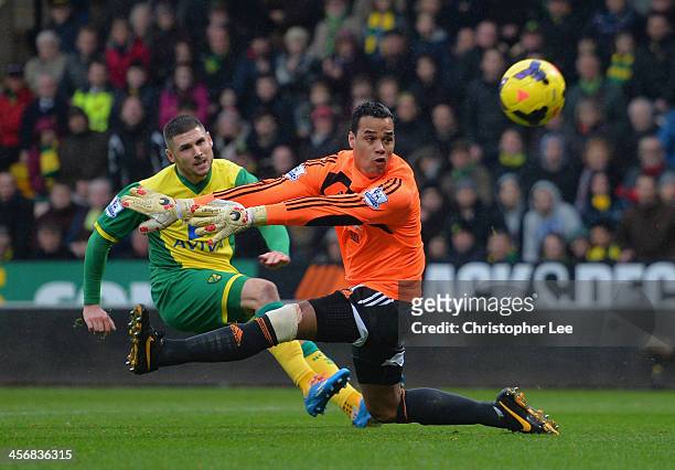 Gary Hooper of Norwich shots past Michael Vorm of Swansea but misses the goal during the Barclays Premier League match between Norwich City and...