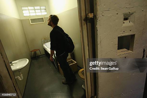 Visitor from Australia looks at a reconstructed prison cell similar to those used by the communist authorities of former East Germany to detain...