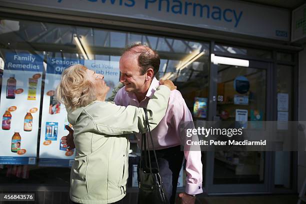 United Kingdom Independence Party candidate Douglas Carswell receives a hug from supporter Asma Jackson as he canvasses for votes on October 8, 2014...