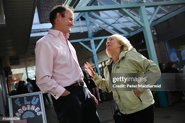 United Kingdom Independence Party candidate Douglas Carswell talks with supporter Asma Jackson as he canvasses for votes on October 8, 2014 in...