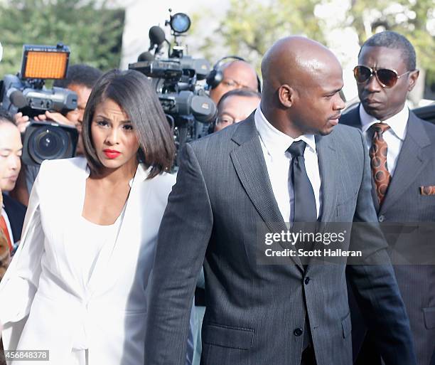 Player Adrian Peterson of the Minnesota Vikings walks with his wife Ashley Brown to a court appearance at the Montgomery County municipal building on...