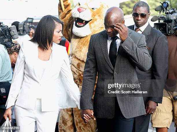 Player Adrian Peterson of the Minnesota Vikings walks with his wife Ashley Brown to a court appearance at the Montgomery County municipal building on...