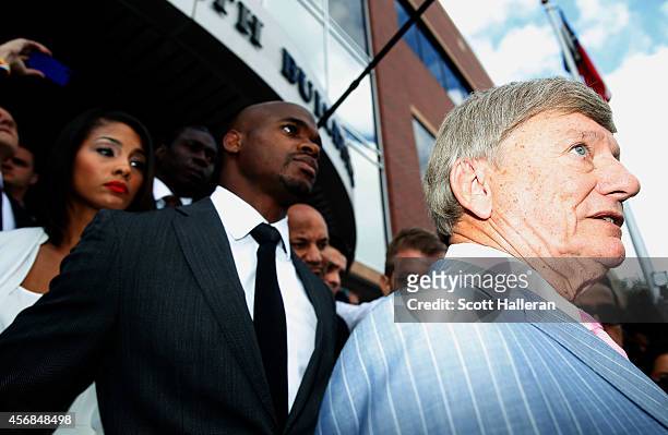 Player Adrian Peterson of the Minnesota Vikings waits with his wife Ashley Brown as his attorney Rusty Hardin speaks with the media after making a...