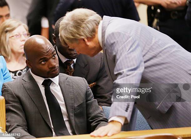 Player Adrian Peterson of the Minnesota Vikings chats with his attorney Rusty Hardin during a court appearance at the Lee G. Alworth Building and the...