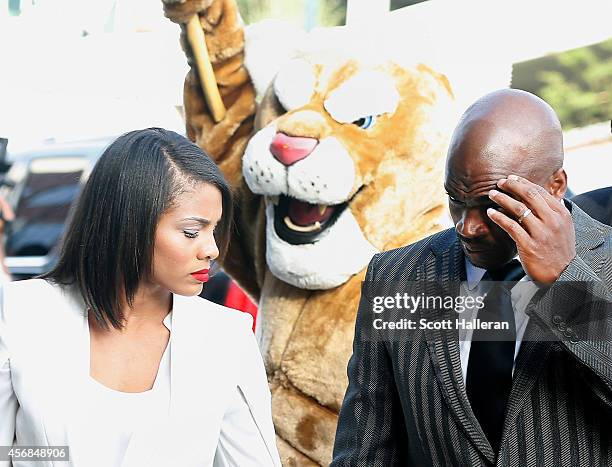 Player Adrian Peterson of the Minnesota Vikings walks with his wife Ashley Brown to a court appearance at the Montgomery County municipal building on...