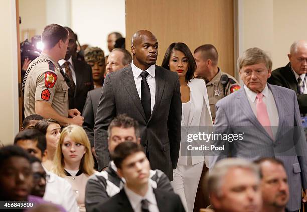 Player Adrian Peterson of the Minnesota Vikings enters the courtroom with his wife Ashley Brown and his attorney Rusty Hardin at the Lee G. Alworth...