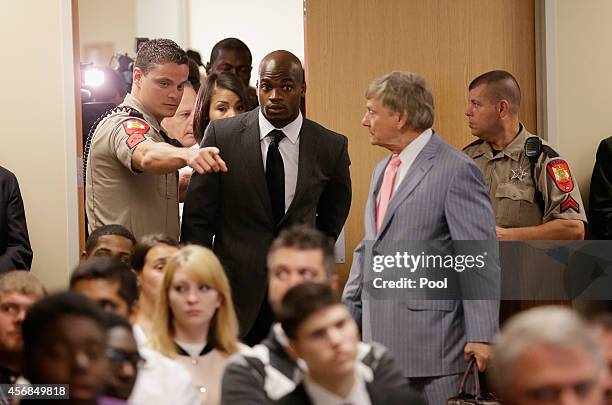 Player Adrian Peterson of the Minnesota Vikings enters the courtroom with his wife Ashley Brown and his attorney Rusty Hardin at the Lee G. Alworth...