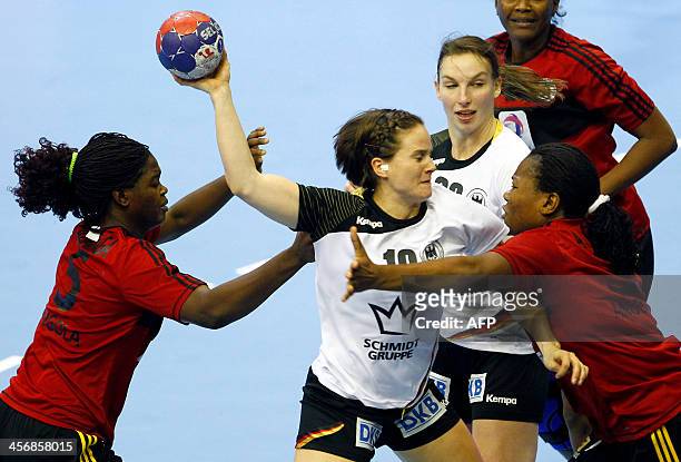 Germany's Anna Loerper and Angie Geschake vies with Angola's Bombo Madalena Calandula and Anastacia Solange Sibo during their Women's Handball World...
