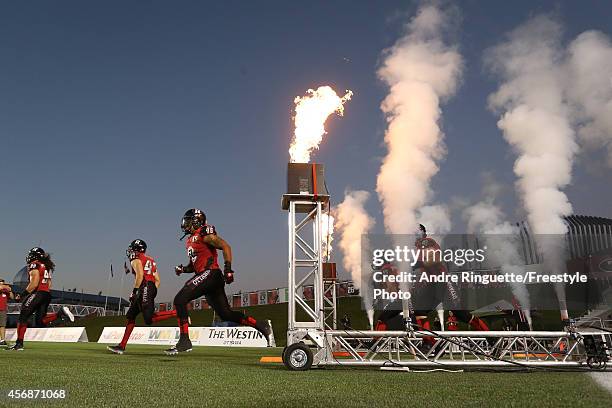 Members of of the Ottawa Redblacks run onto the field during player introductions prior to playing against the Montreal Alouettes during a CFL game...