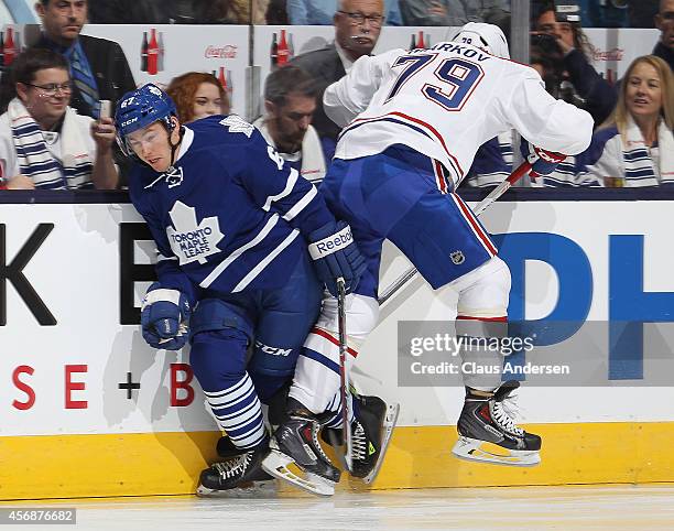 Andrei Markov of the Montreal Canadiens lays a hit on Brandon Kozun of the Toronto Maple Leafs in their NHL season opener at the Air Canada Centre on...