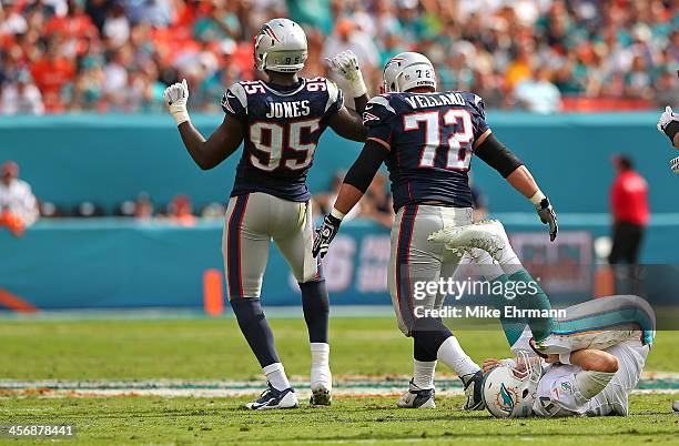 Chandler Jones and Joe Vellano of the New England Patriots celebrate a sack on Ryan Tannehill of the Miami Dolphins during a game at Sun Life Stadium...