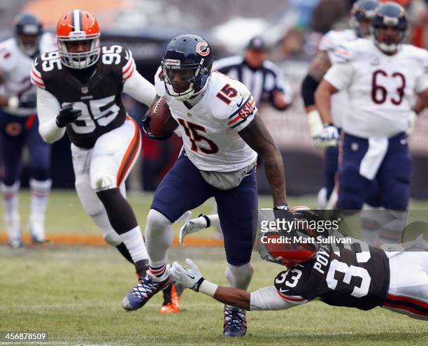 Wide receiver Brandon Marshall of the Chicago Bears runs the ball by defensive lineman Armonty Bryant and Jordan Poyer of the Cleveland Browns at...