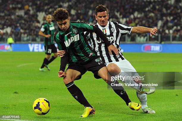 Luca Antei of US Sassuolo Calcio is challenged by Simone Padoin of Juventus during the Serie A match between Juventus and US Sassuolo Calcio at...