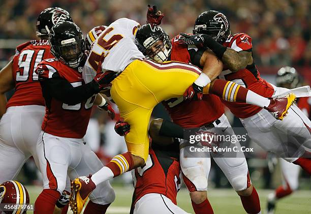 Alfred Morris of the Washington Redskins is tackled by Sean Weatherspoon, Paul Worrilow and William Moore of the Atlanta Falcons at Georgia Dome on...