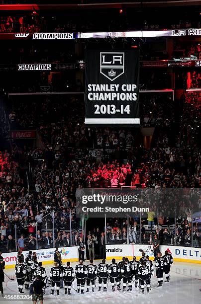 The Los Angeles Kings stand on the ice as the Stanley Cup Championship banner is raised to the rafters during ceremonies before the game with the San...