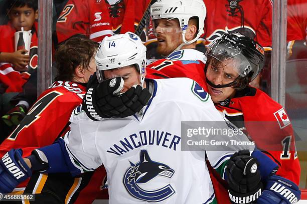 Mikael Backlund of the Calgary Flames gets into a physical altercation with Alexandre Burrows of the Vancouver Canucks in their NHL season opener at...