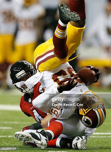 Zeke Motta of the Atlanta Falcons upends Santana Moss of the Washington Redskins after a reception at Georgia Dome on December 15, 2013 in Atlanta,...