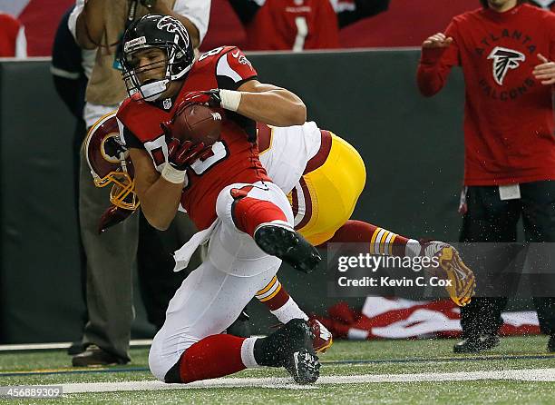 Tony Gonzalez of the Atlanta Falcons pulls in this reception against Reed Doughty of the Washington Redskins at Georgia Dome on December 15, 2013 in...