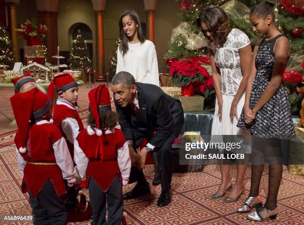 President Barack Obama, First Lady Michelle Obama and their daughters Sasha and Malia speak with children dressed as elves, who are or were patients...