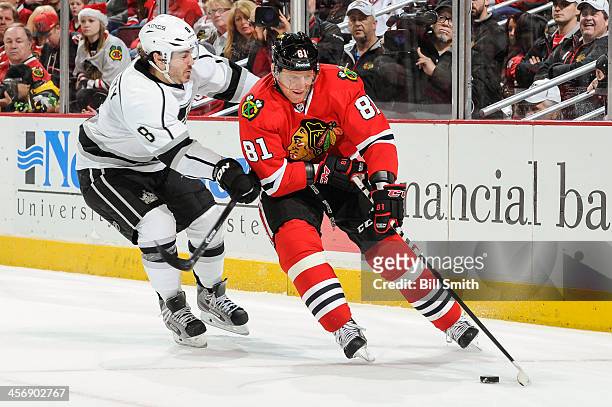 Marian Hossa of the Chicago Blackhawks grabs the puck as Drew Doughty of the Los Angeles Kings pushes from behind during the NHL game on December 15,...