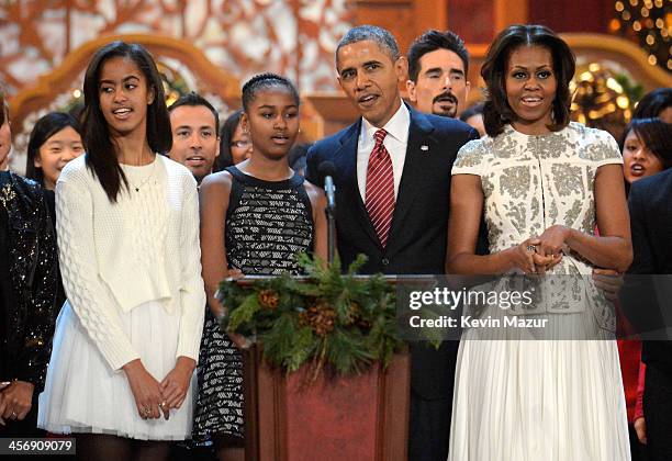 Malia Obama, Sasha Obama, US President Barack Obama, and First Lady Michelle Obama speak onstage at TNT Christmas in Washington 2013 at the National...