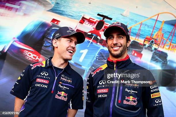 Sebastian Vettel of Germany and Infiniti Red Bull Racing speaks with Daniel Ricciardo of Australia and Infiniti Red Bull Racing at a signing session...